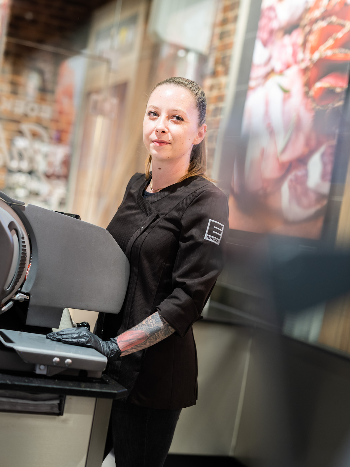 Metzgerin Antonia Pentavec an der Fleischtheke eines EDEKA-Marktes