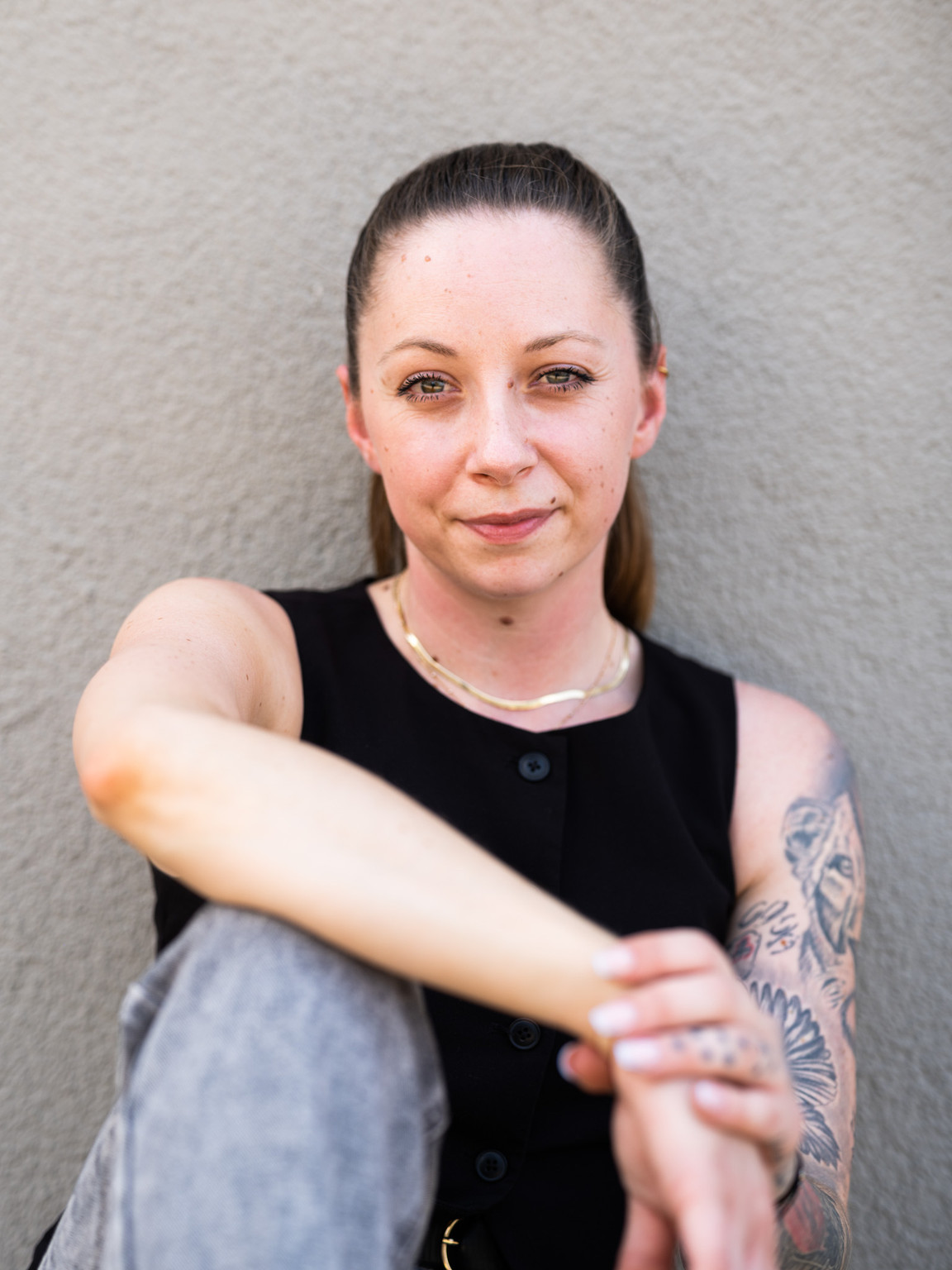 Antonia Pentavec sitzt vor einer grauen Wand